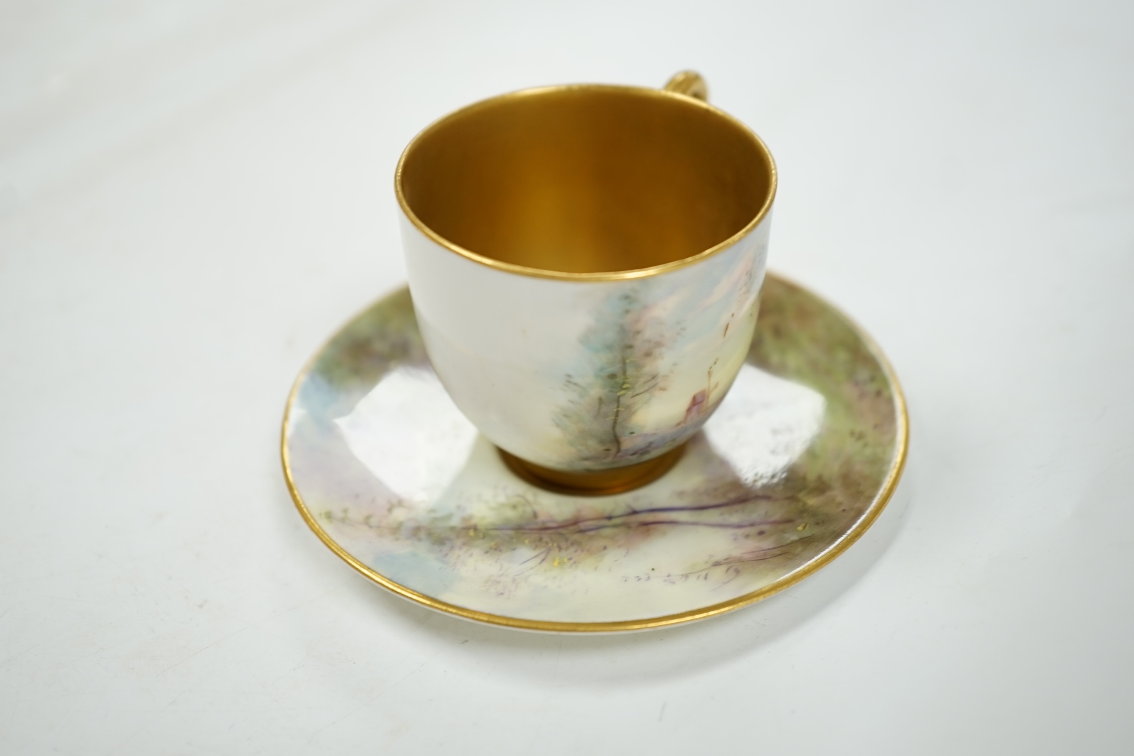 A Royal Worcester cup and saucer, painted by Harry Davis with figures in a landscape, saucer 9.5cm diameter. Condition - good